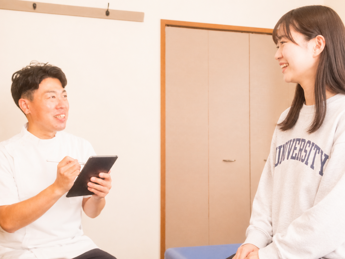 八王子のつきいち整体で学生の問診を行っている様子